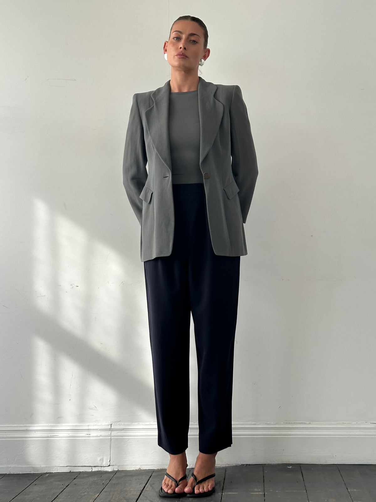 Giorgio Armani 1990s high-waisted pure wool tapered trousers in dark color, front view showing tailored fit and waistband.