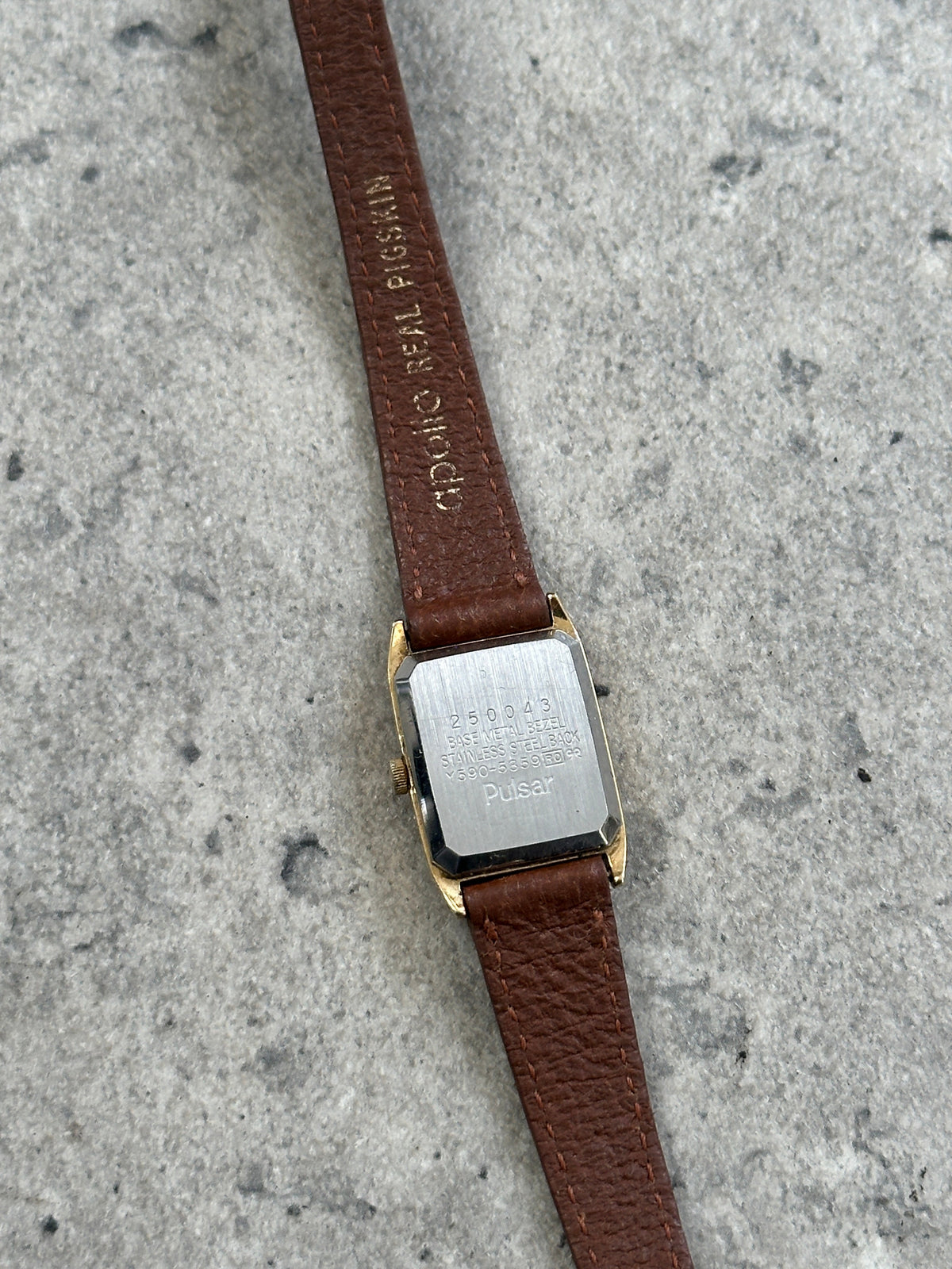 Vintage Pulsar 1980s gold-tone leather watch with classic round dial and leather strap, showcasing retro style and elegant design.