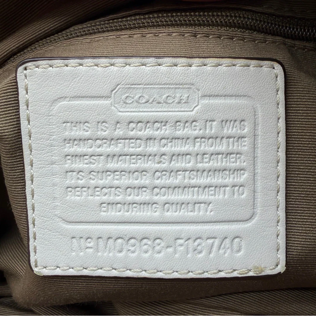 https://cdn.shopify.com/s/files/1/0564/9376/8855/files/Coach_Schultertasche_Signature_large_beige___weiss_vintage8004.webp?v=1780489241