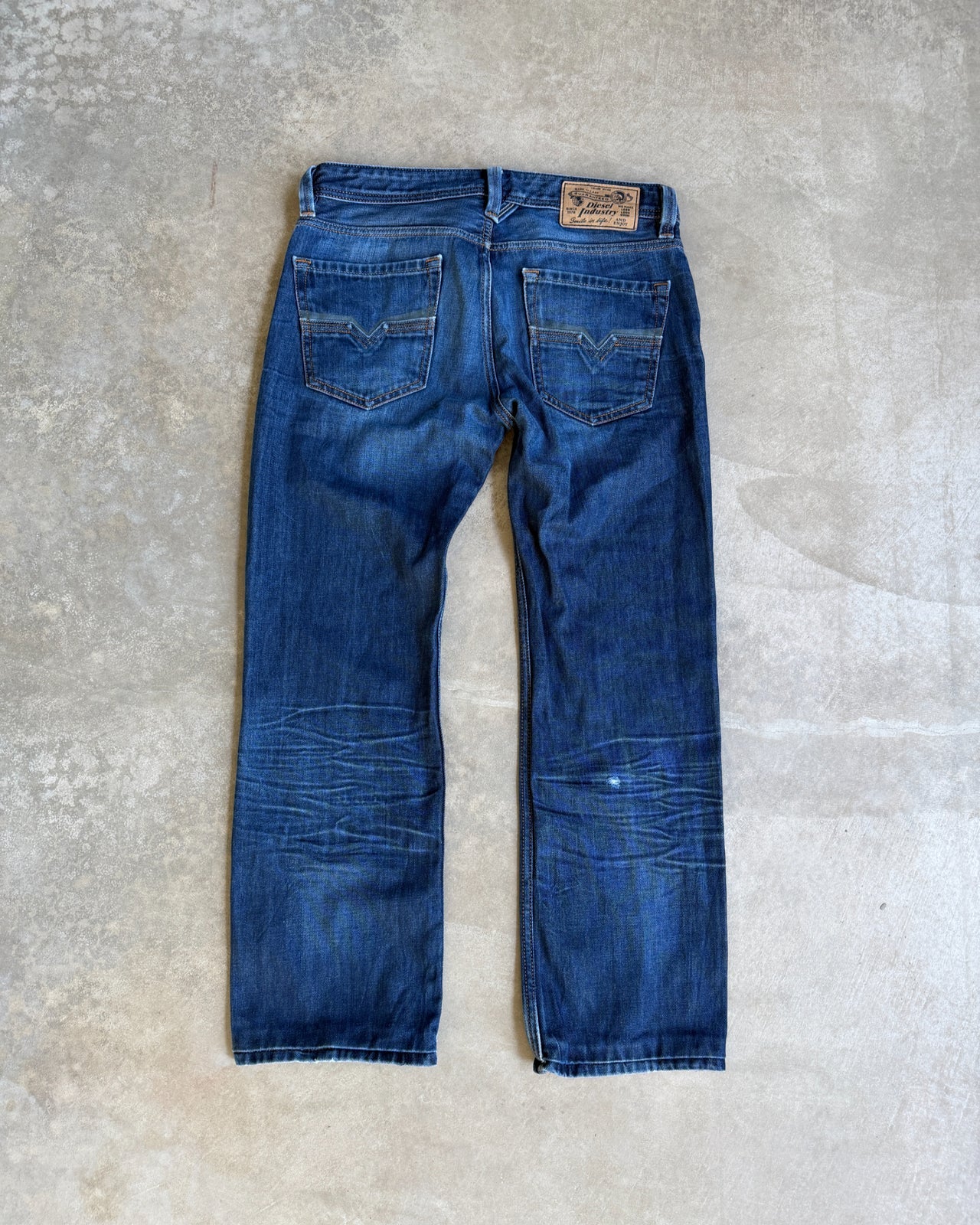 Diesel Mid Blue Distressed Straight Leg Jeans – W30/L28-on a concrete background