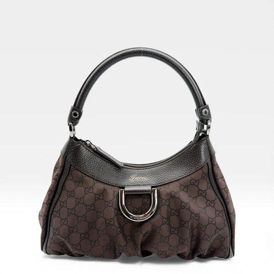 https://cdn.shopify.com/s/files/1/0564/9376/8855/files/Gucci_Handtasche_D-Ring_aus_Nylon_monogram_dunkelbraun_vintage_GG_handbag_5285.webp?v=1765384294