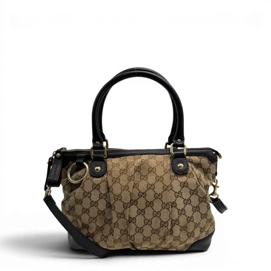 https://cdn.shopify.com/s/files/1/0564/9376/8855/files/Gucci_Handtasche_Sukey_mit_Umhangegurt_monogram_beige_vintage_GG2324.webp?v=1779968392