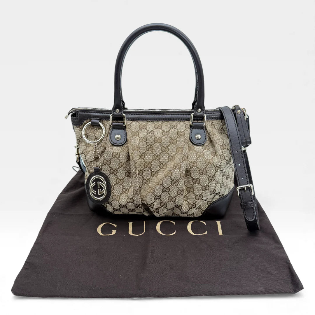 https://cdn.shopify.com/s/files/1/0564/9376/8855/files/Gucci_Handtasche_Sukey_mit_Umhangegurt_monogram_beige_vintage_GG_handbag_5078.webp?v=1765383774