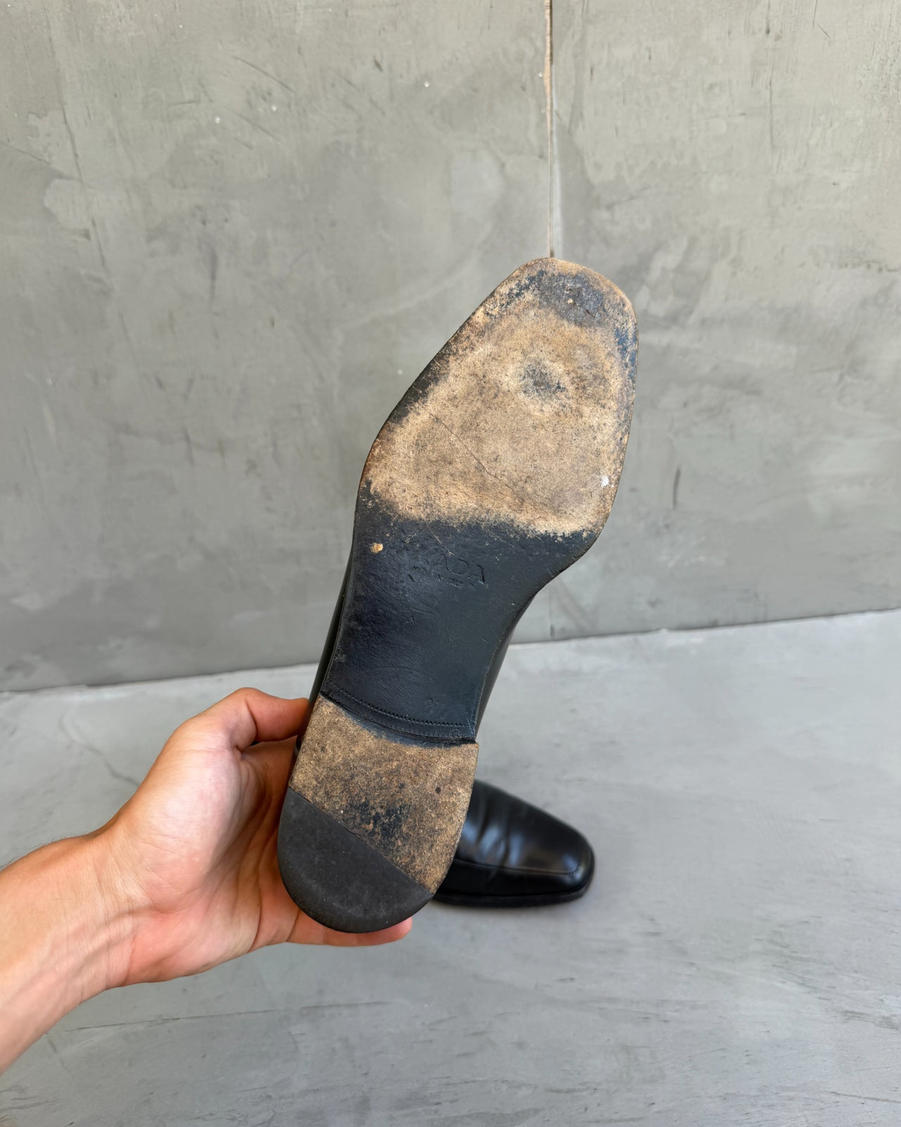 Prada Black Leather Loafers – UK 8.5-on a concrete background