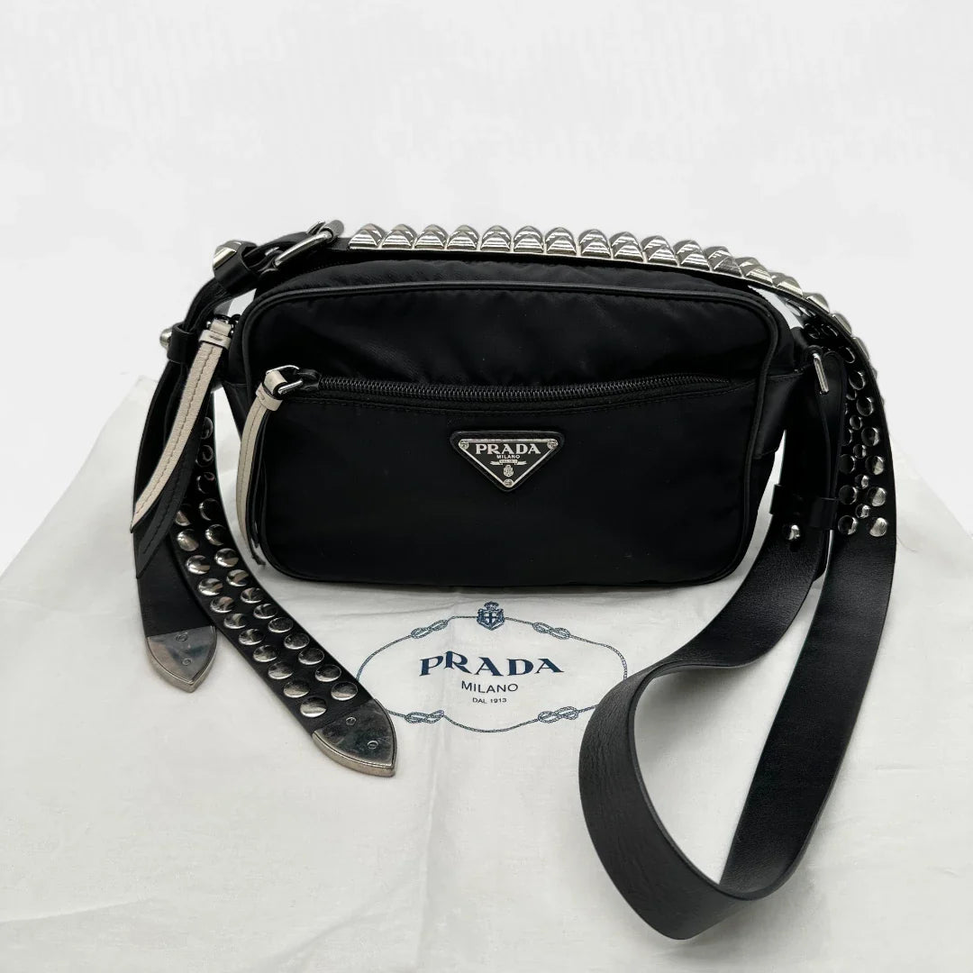 https://cdn.shopify.com/s/files/1/0564/9376/8855/files/Prada_Umhangetasche_AW18_mit_Nieten_aus_Nylon_schwarz_vintage_crossbody8190.webp?v=1758632969