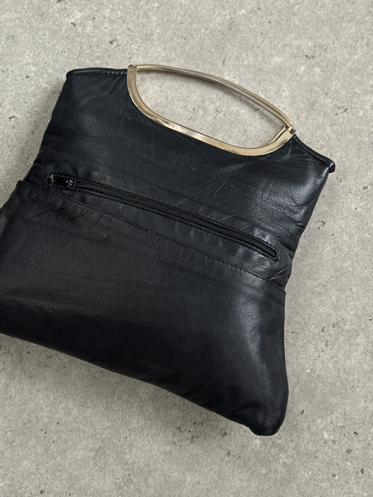 Vintage 1990s leather handbag with classic design, featuring a structured shape and aged leather finish.