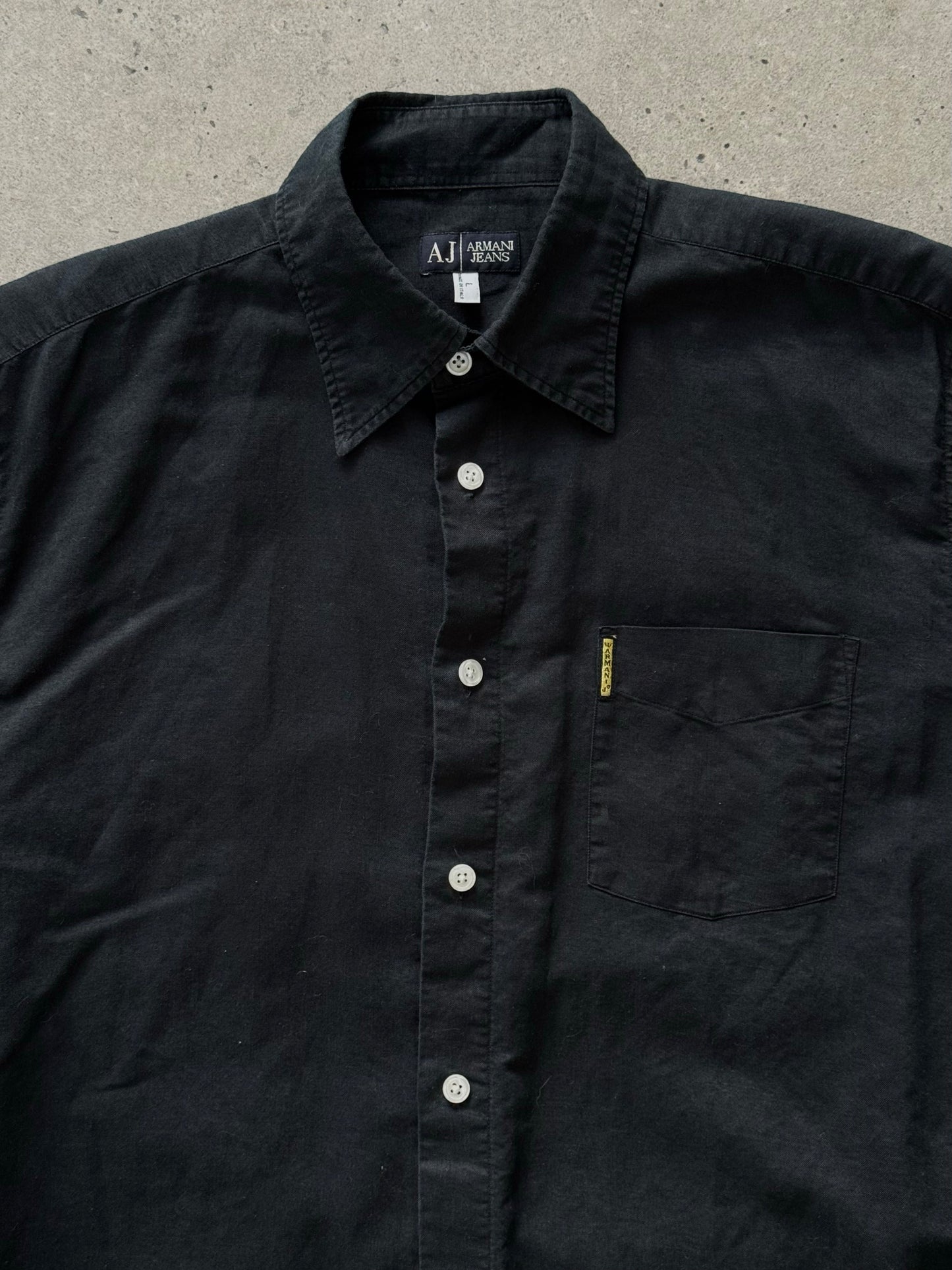 Armani Jeans 1990s pure cotton short sleeve shirt in light color, with classic collar and button closure, displayed on a hanger.