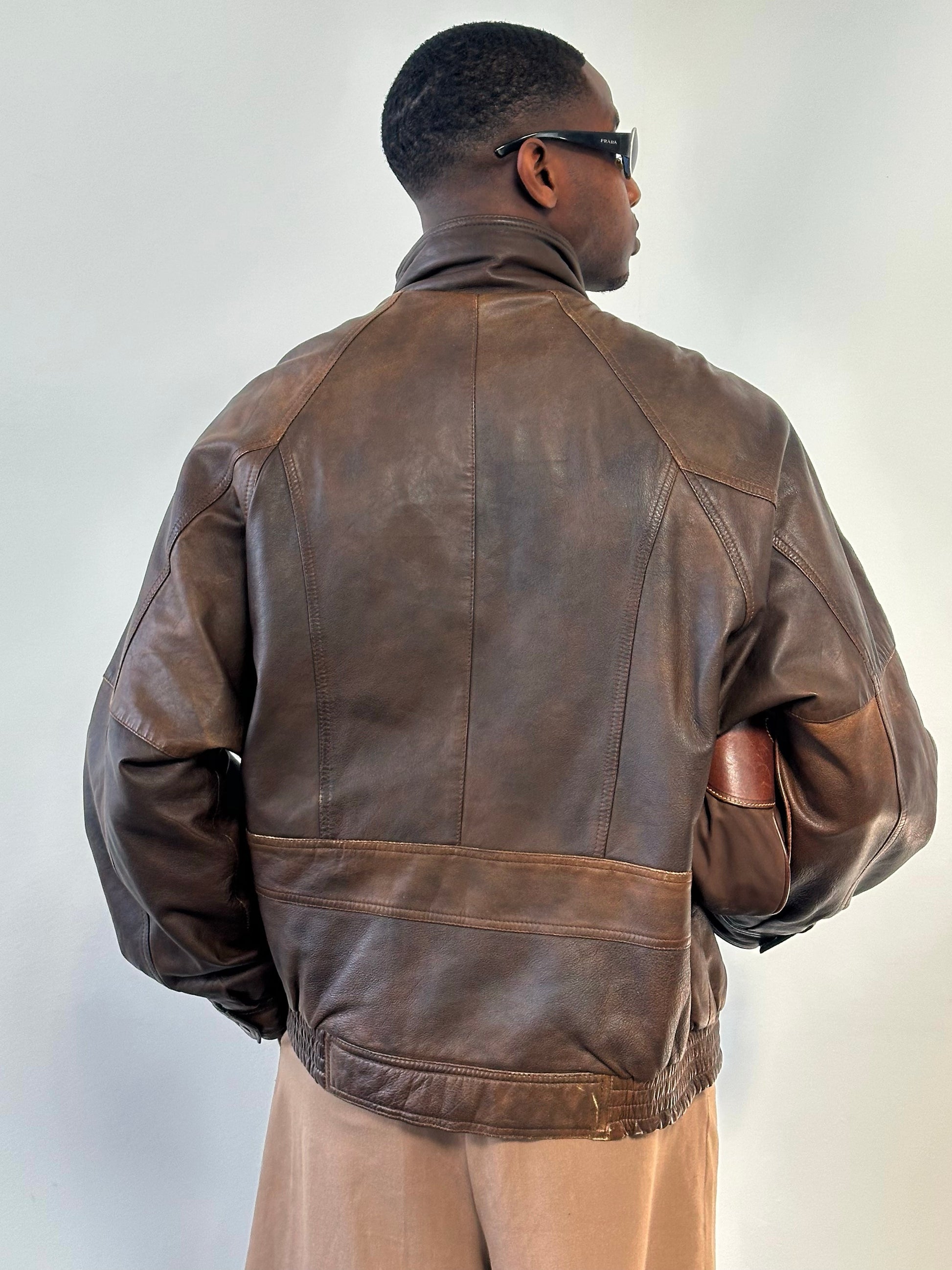 Vintage 1990s leather high neck bomber jacket in XL, showing the classic collar, shoulder details, and front zipper closure.