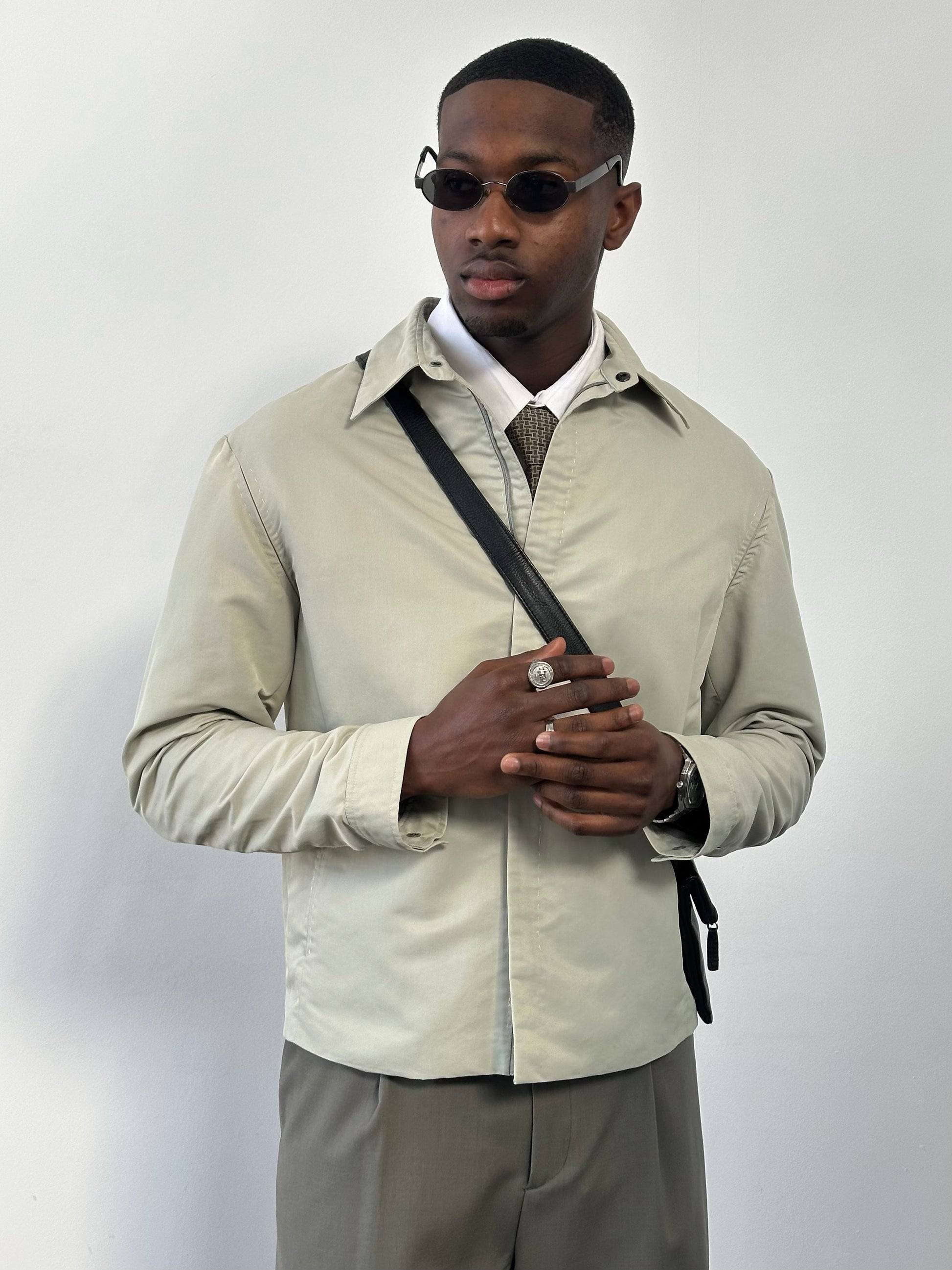 Gianfranco Ferre 1990s showerproof minimal jacket in size L, featuring sleek design and lightweight fabric, shown on a hanger.