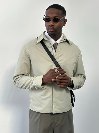 Gianfranco Ferre 1990s showerproof minimal jacket in size L, featuring sleek design and lightweight fabric, shown on a hanger.