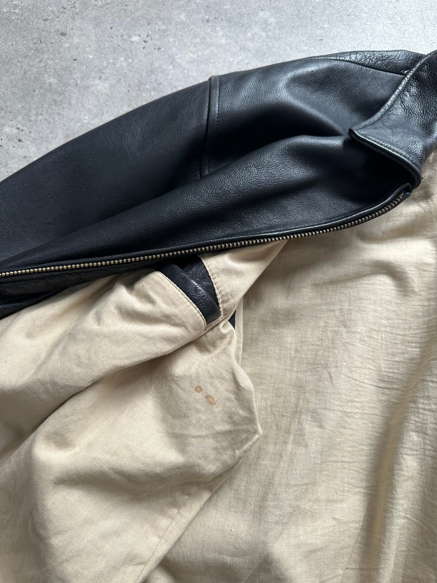Vintage 1990s heavyweight leather jacket in black with minimal design, XXL size, featuring classic leather texture and sturdy construction.