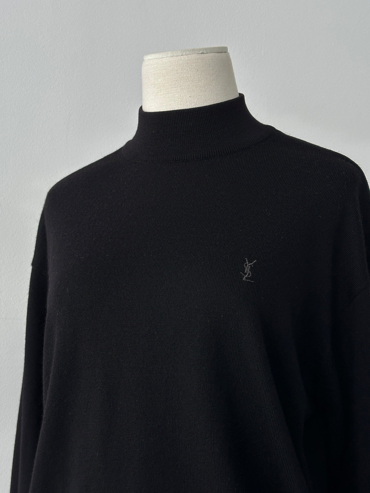 Yves Saint Laurent 1990s wool high neck jumper in black with ribbed collar and long sleeves, displayed flat.