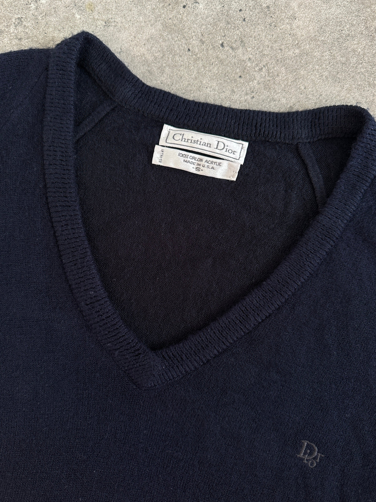 Christian Dior 1990s V-neck logo jumper in black and white, featuring the Dior logo, displayed on a mannequin.