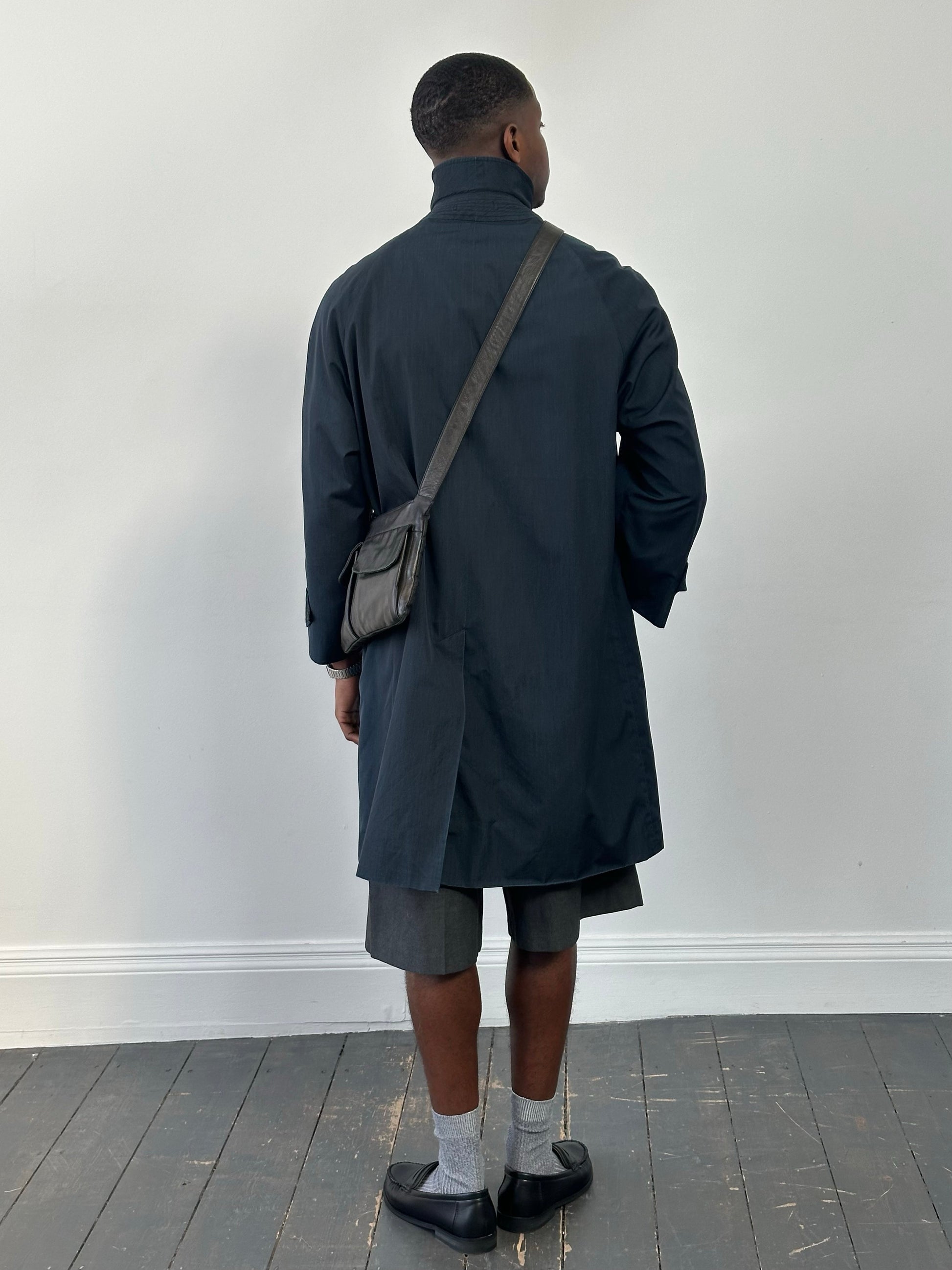 Burberry 1990s high neck trench coat with concealed placket in beige, displayed on a hanger, showcasing classic trench style and tailored fit.
