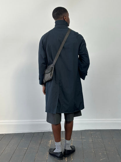 Burberry 1990s high neck trench coat with concealed placket in beige, displayed on a hanger, showcasing classic trench style and tailored fit.