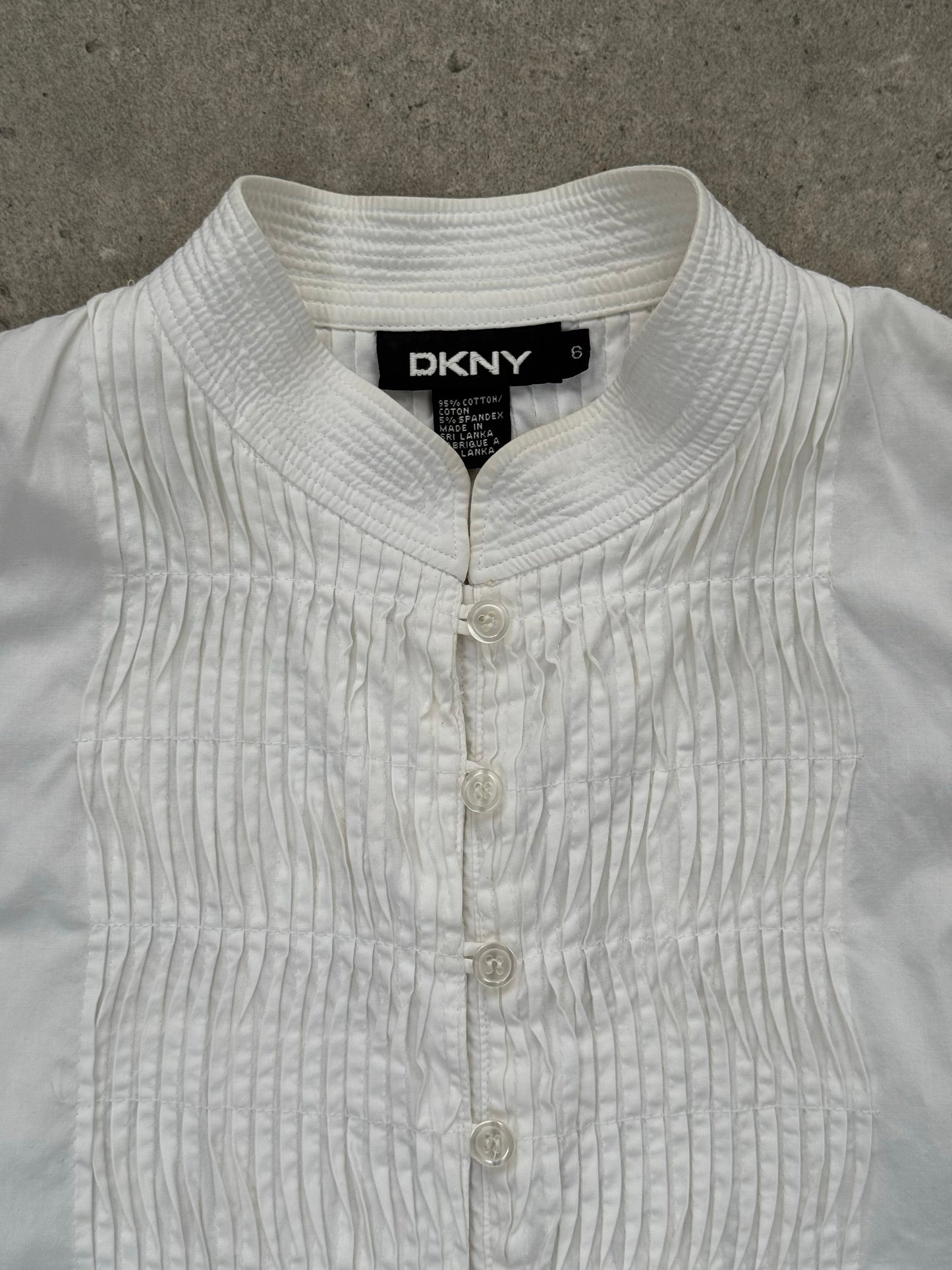 DKNY 2000s pleated cotton sleeveless top in white, featuring a fitted bodice and pleated design, size M.