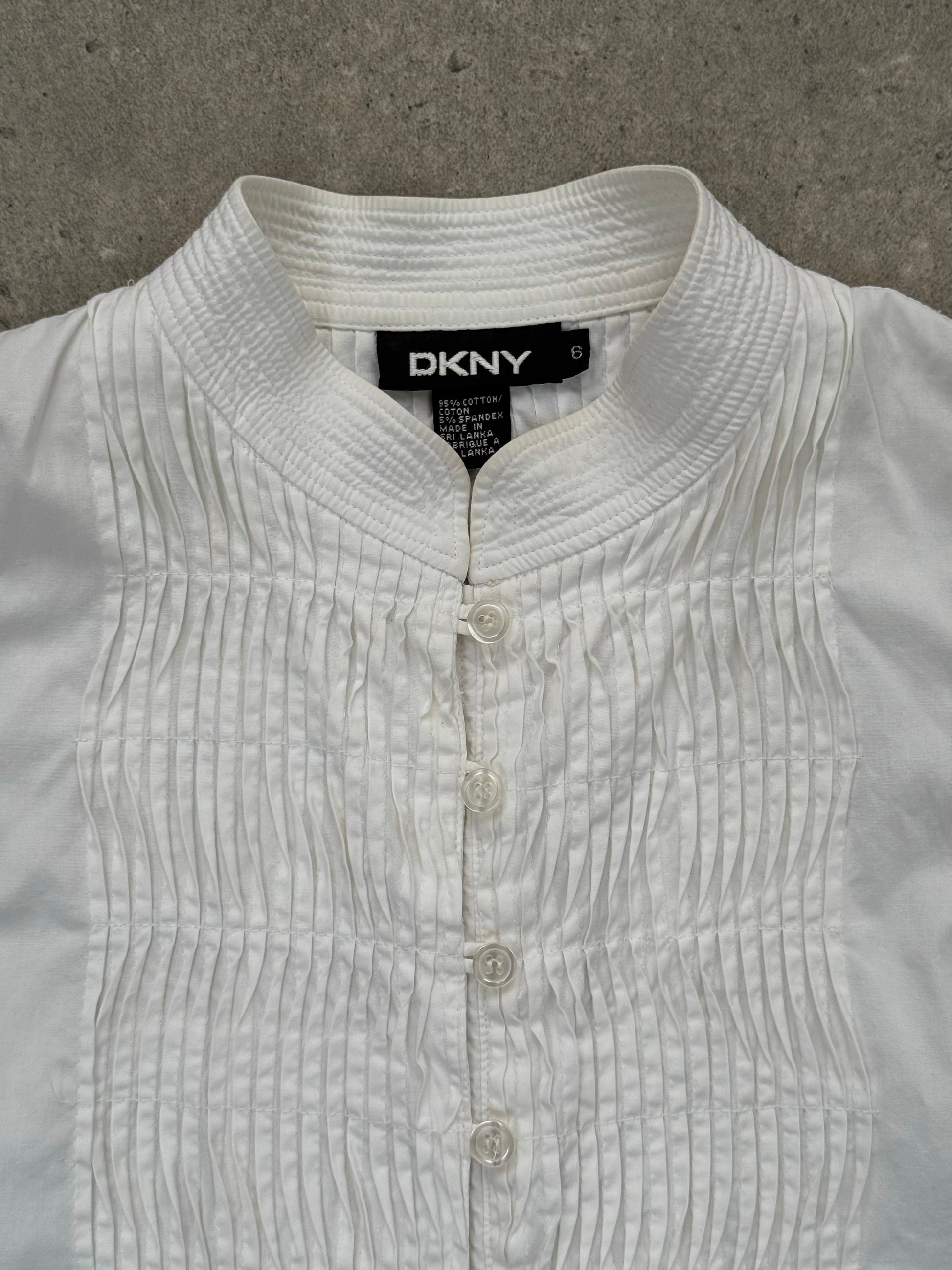 DKNY 2000s pleated cotton sleeveless top in white, featuring a fitted bodice and pleated design, size M.