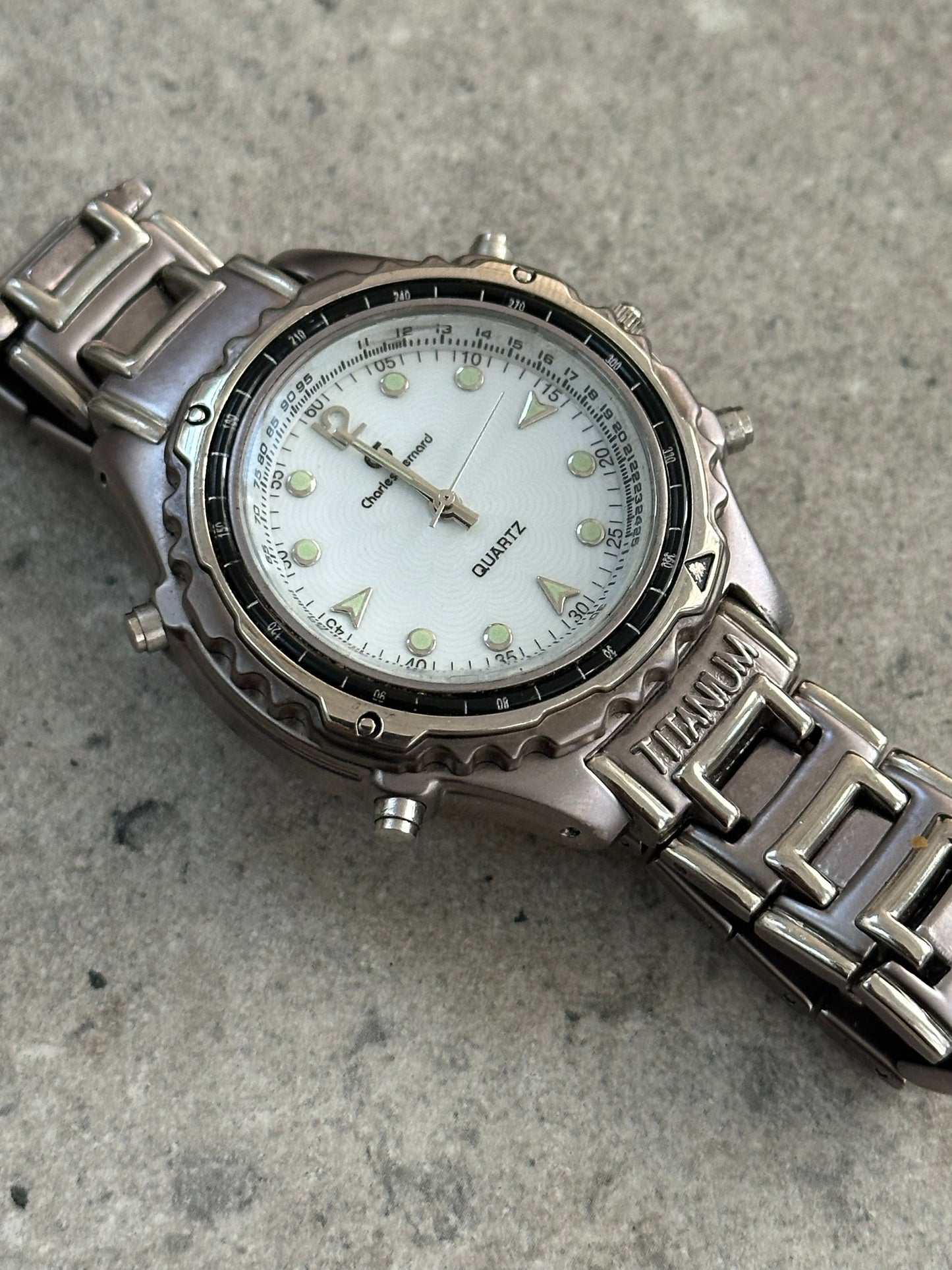 Vintage 1990s Titanium Quartz Sports Watch with black dial, stainless steel band, and chronograph features.
