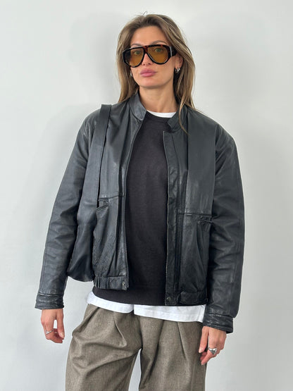 Vintage 1990s leather bomber jacket in size M, featuring classic design and authentic distressed leather style.