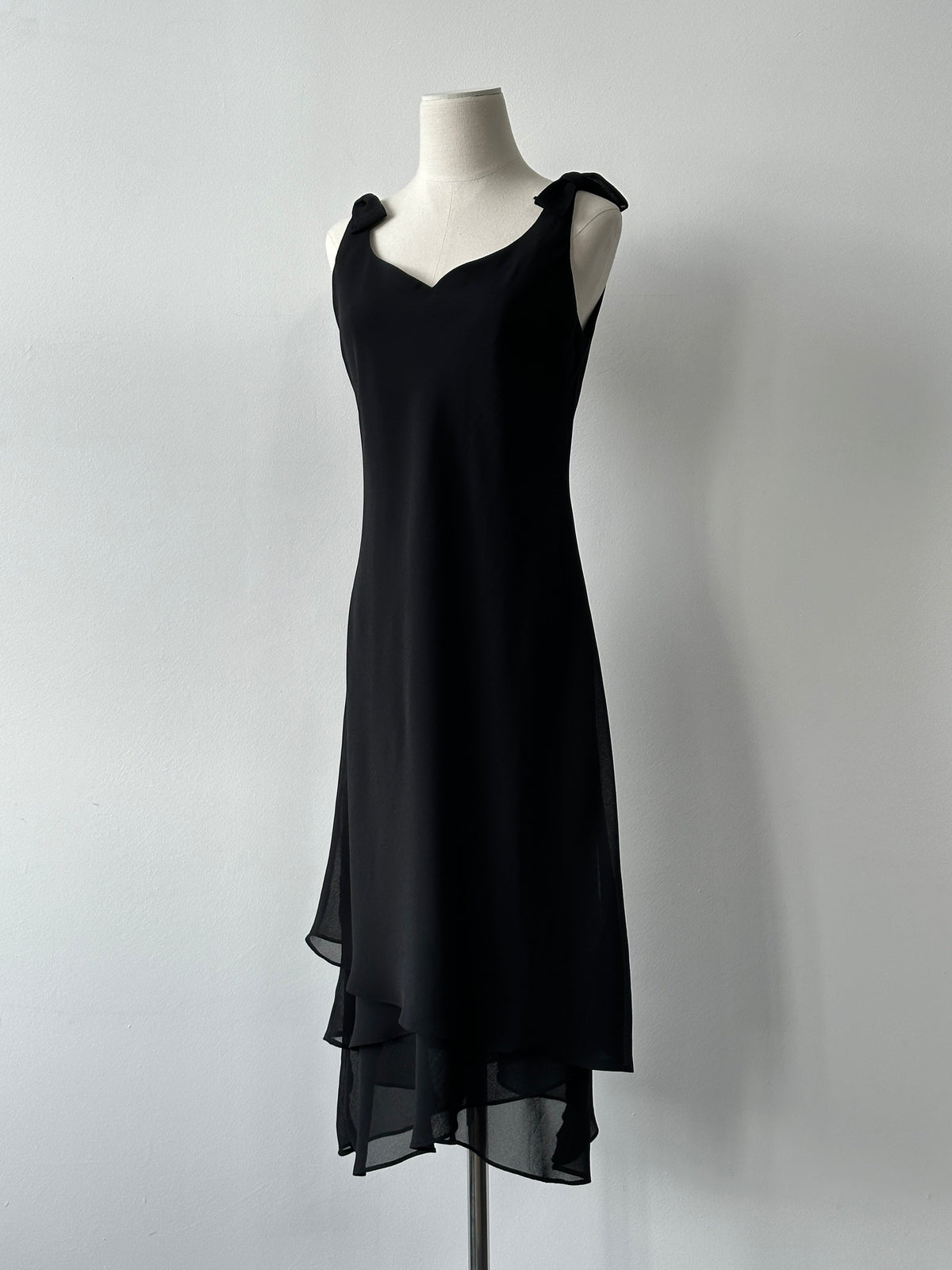 Vintage 1990s layered sleeveless midi dress, size small, with a retro style and flowing fabric, displayed on a hanger.