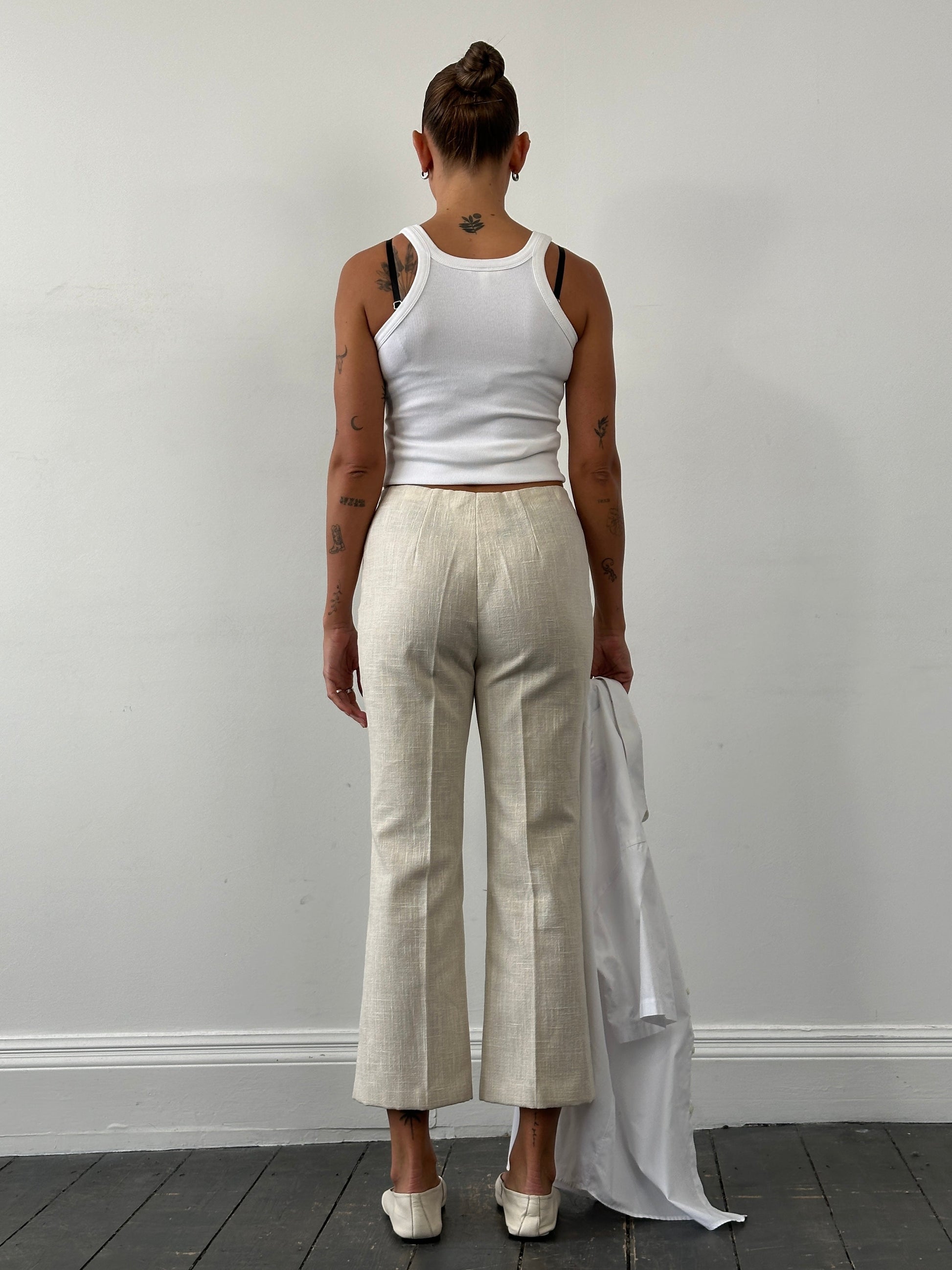 Vintage 1990s linen high waist cropped trousers, W26, shown flat with front pockets and relaxed fit, in natural beige color.
