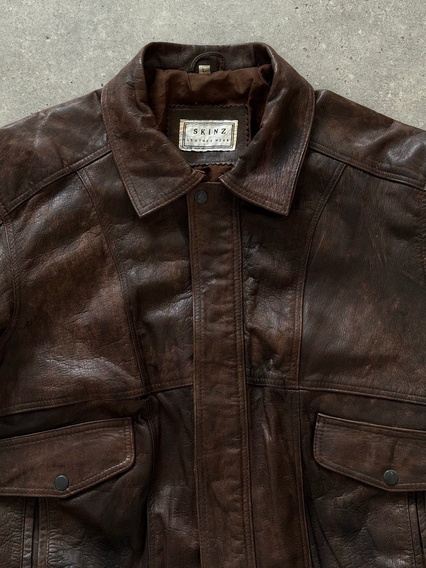 Vintage 1990s distressed leather bomber jacket, size M, with rugged styling and classic design.