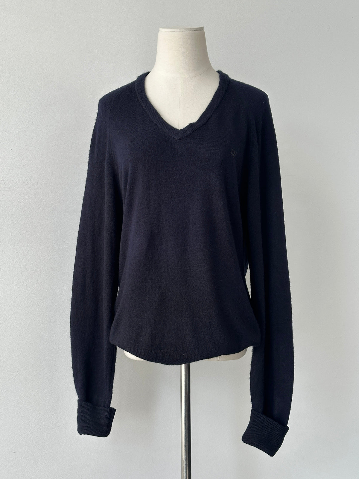 Christian Dior 1990s V-neck logo jumper in black, featuring the iconic Dior logo on the front, worn by a model.