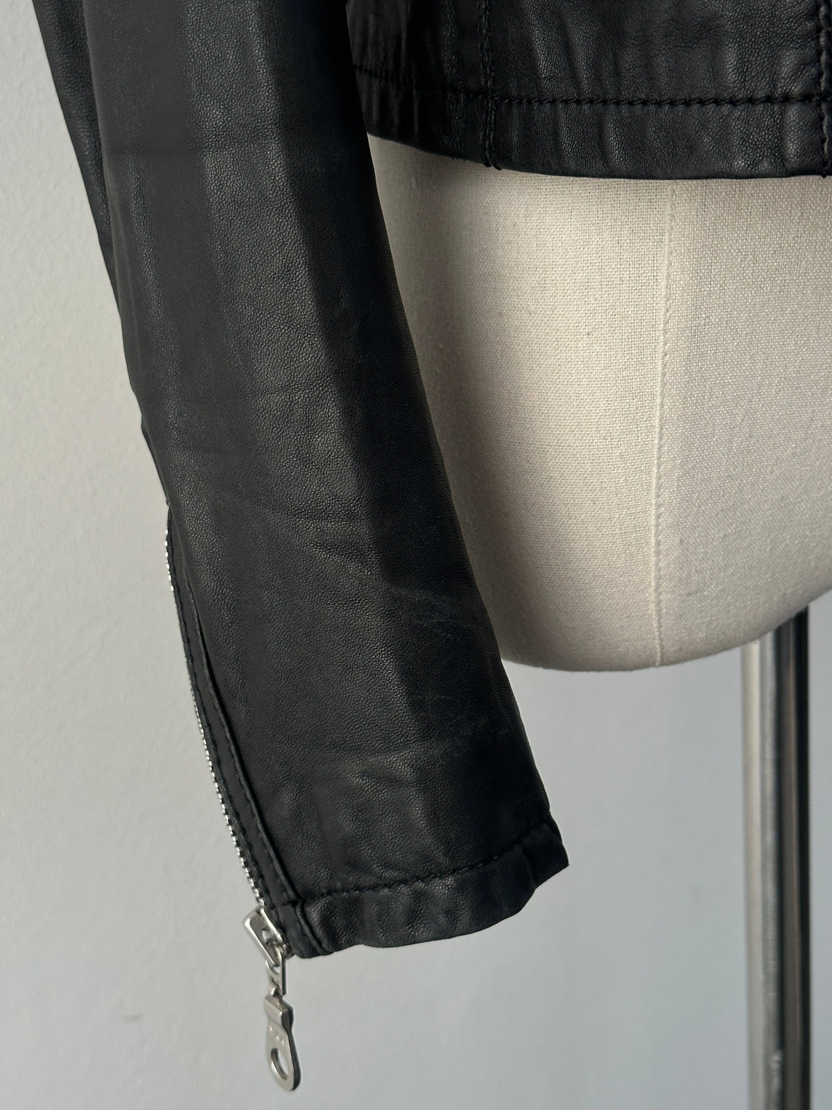 Vintage 2000s fitted XS Moto Lamb leather jacket, stylish black leather jacket with a sleek, classic design and zippered details.