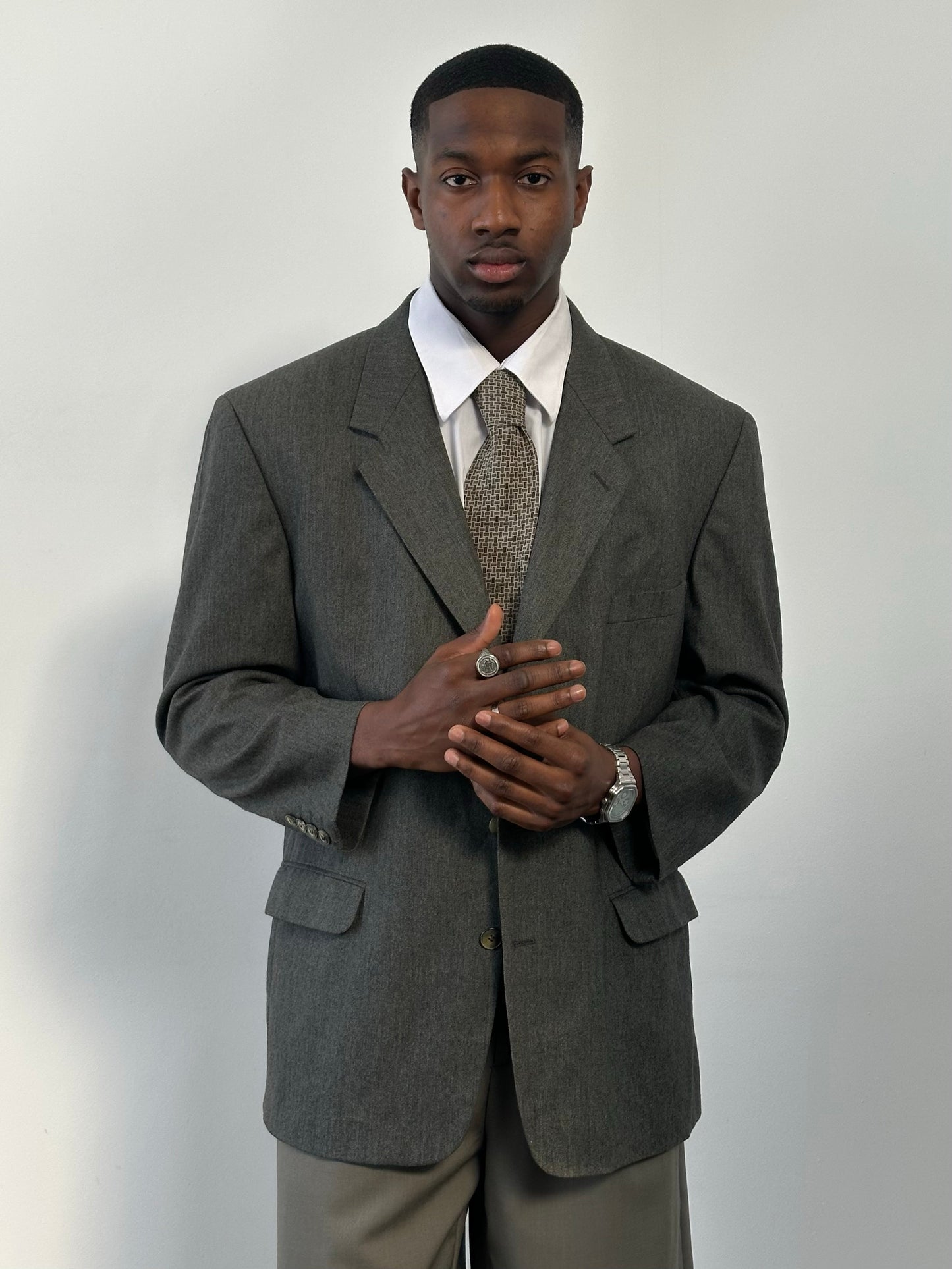 Yves Saint Laurent 1990s pure wool single-breasted blazer in size 46R, shown hanging with detailed fabric texture and classic design.