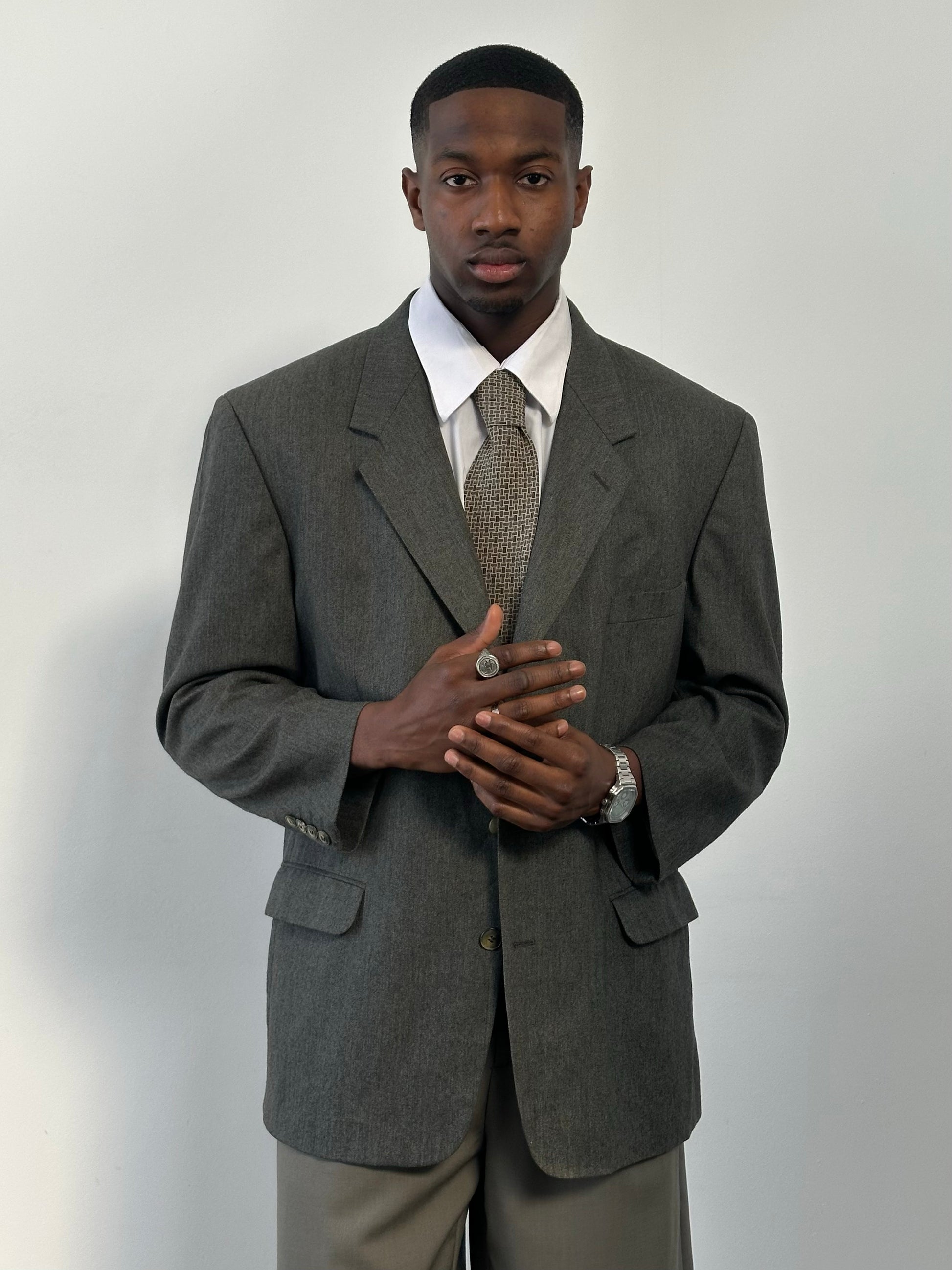 Yves Saint Laurent 1990s pure wool single-breasted blazer in size 46R, shown hanging with detailed fabric texture and classic design.