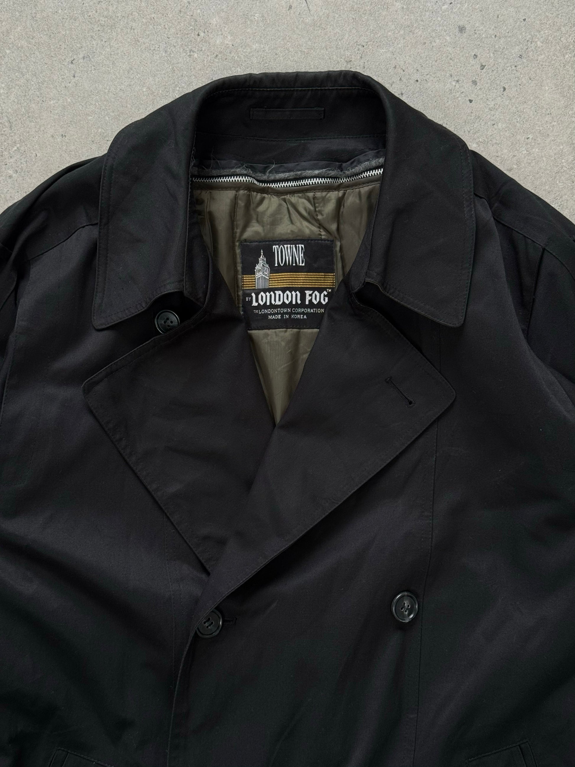London Fog Towne 1990s double-breasted belted trench coat hanging with a classic design and neutral color.