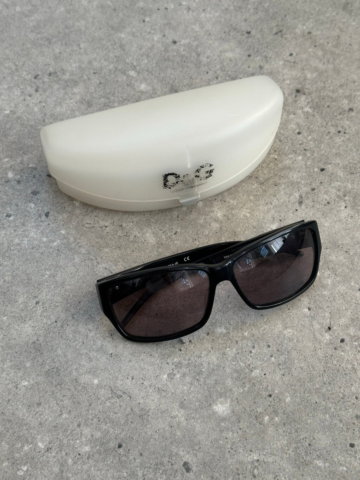 Dolce & Gabbana 2000s rectangle logo sunglasses with black frames and dark lenses on a white background.