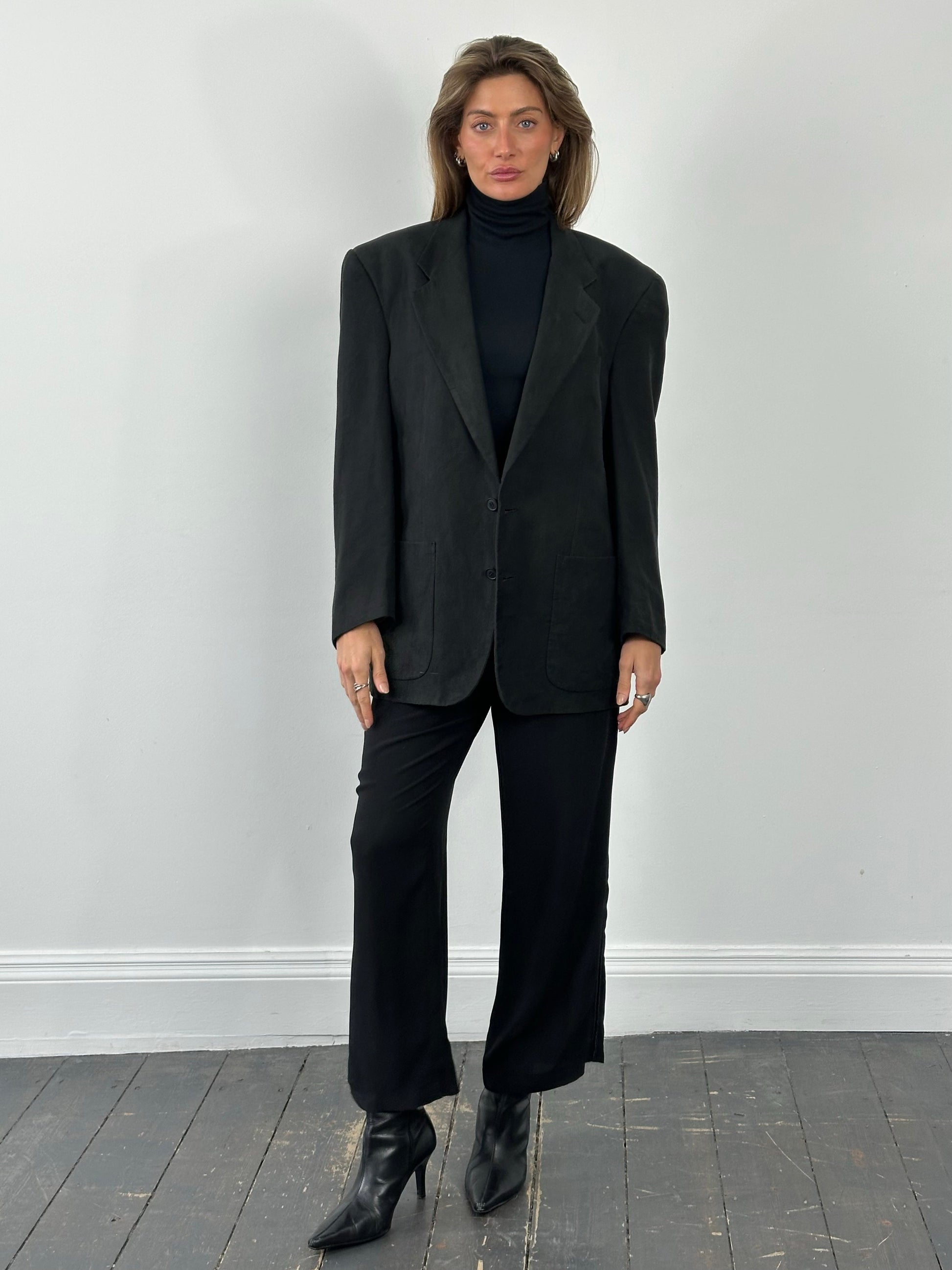 Christian Dior Monsieur 1980s single-breasted blazer in size L/XL displayed on a hanger, showing classic tailored design and dark fabric.