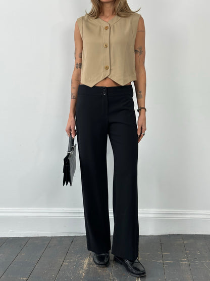 Armani Collezioni 1990s wool wide-leg trouser in size W30, beige color, shown on a hanger with a blurred background.