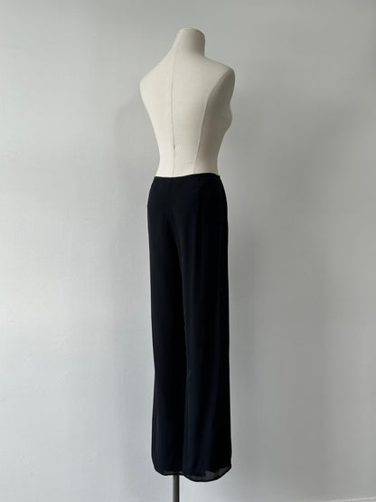 Vintage 1990s pure silk wide leg trousers in size W30, showcasing smooth fabric and relaxed fit on a hanger.