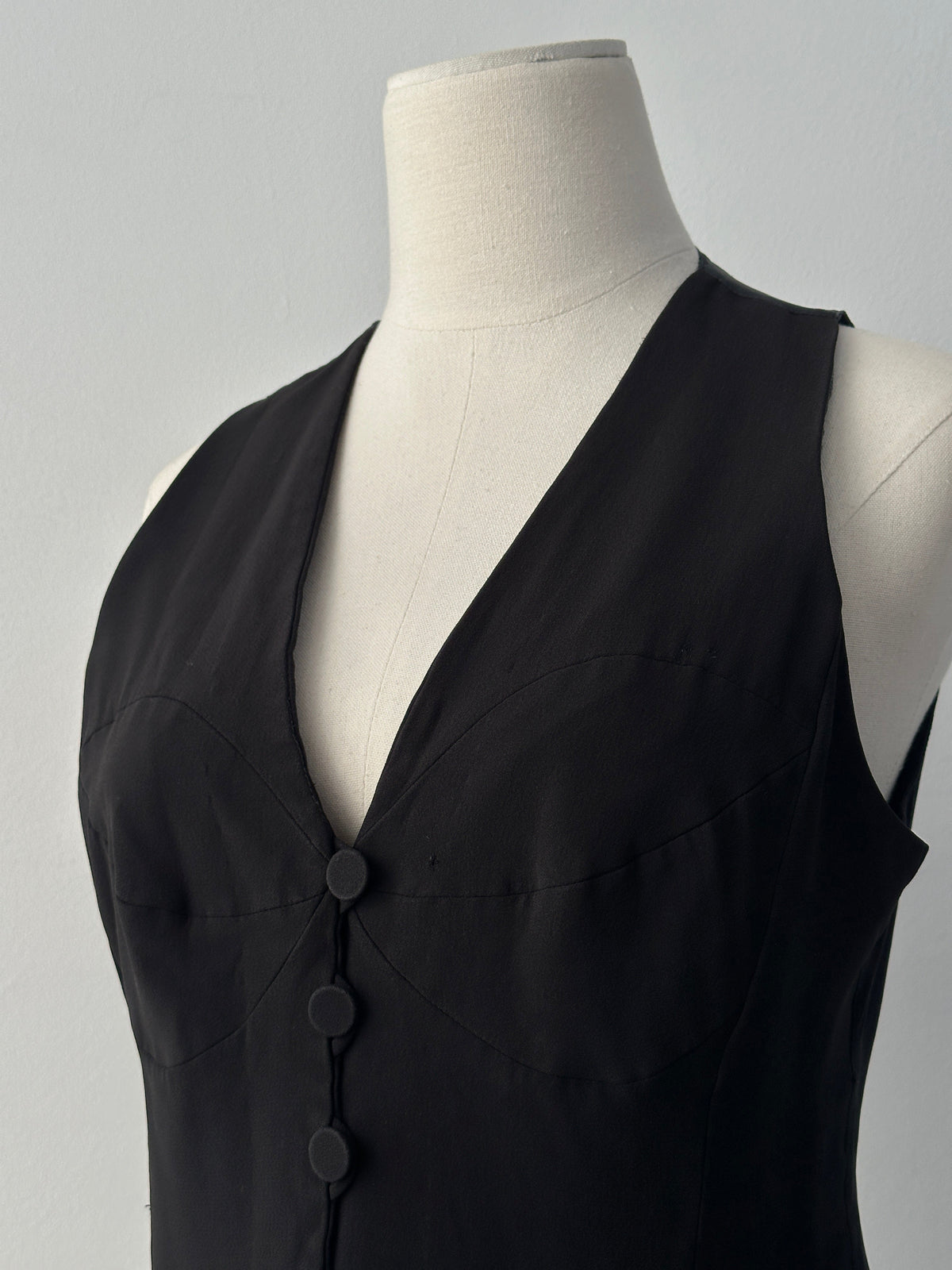 Emporio Armani 1990s fitted tailored single-button waistcoat in dark fabric, close-up showing sleek design and classic style.