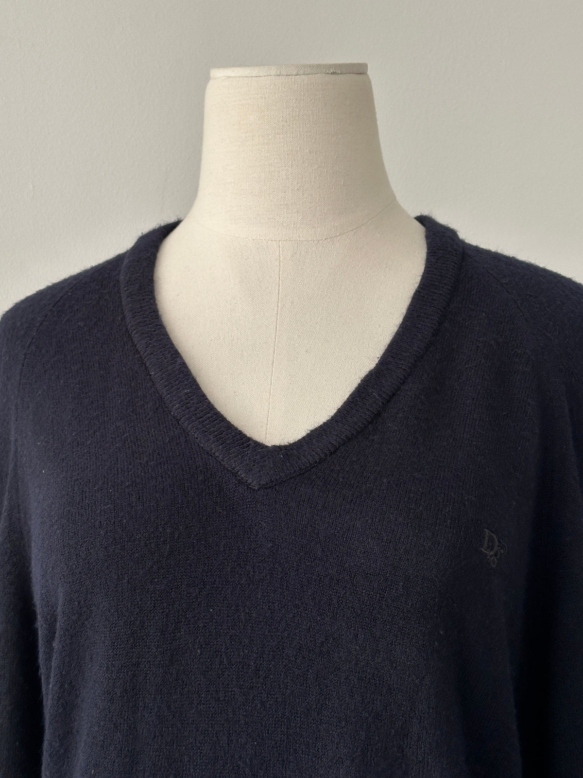 Christian Dior 1990s V-neck logo jumper in black, featuring the iconic Dior branding and classic knit design, worn casually.