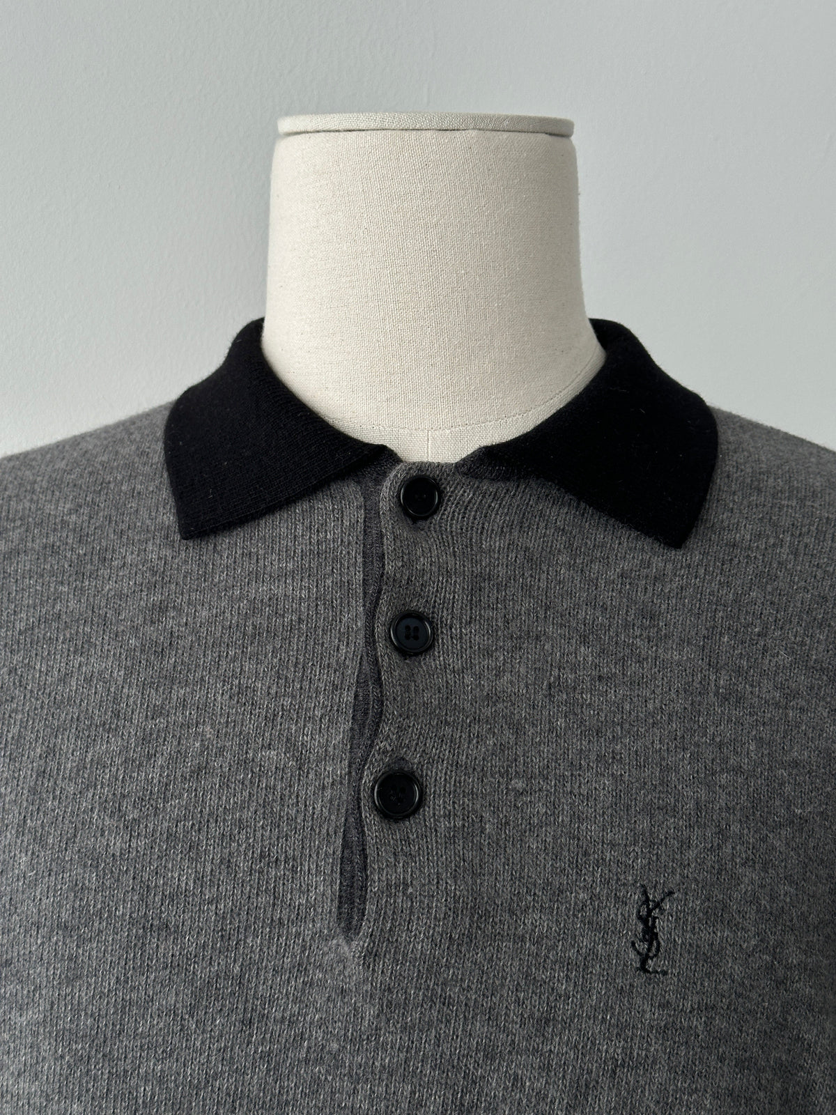 Yves Saint Laurent 1990s wool polo jumper in navy with ribbed collar and cuffs, displayed flat on a neutral background.