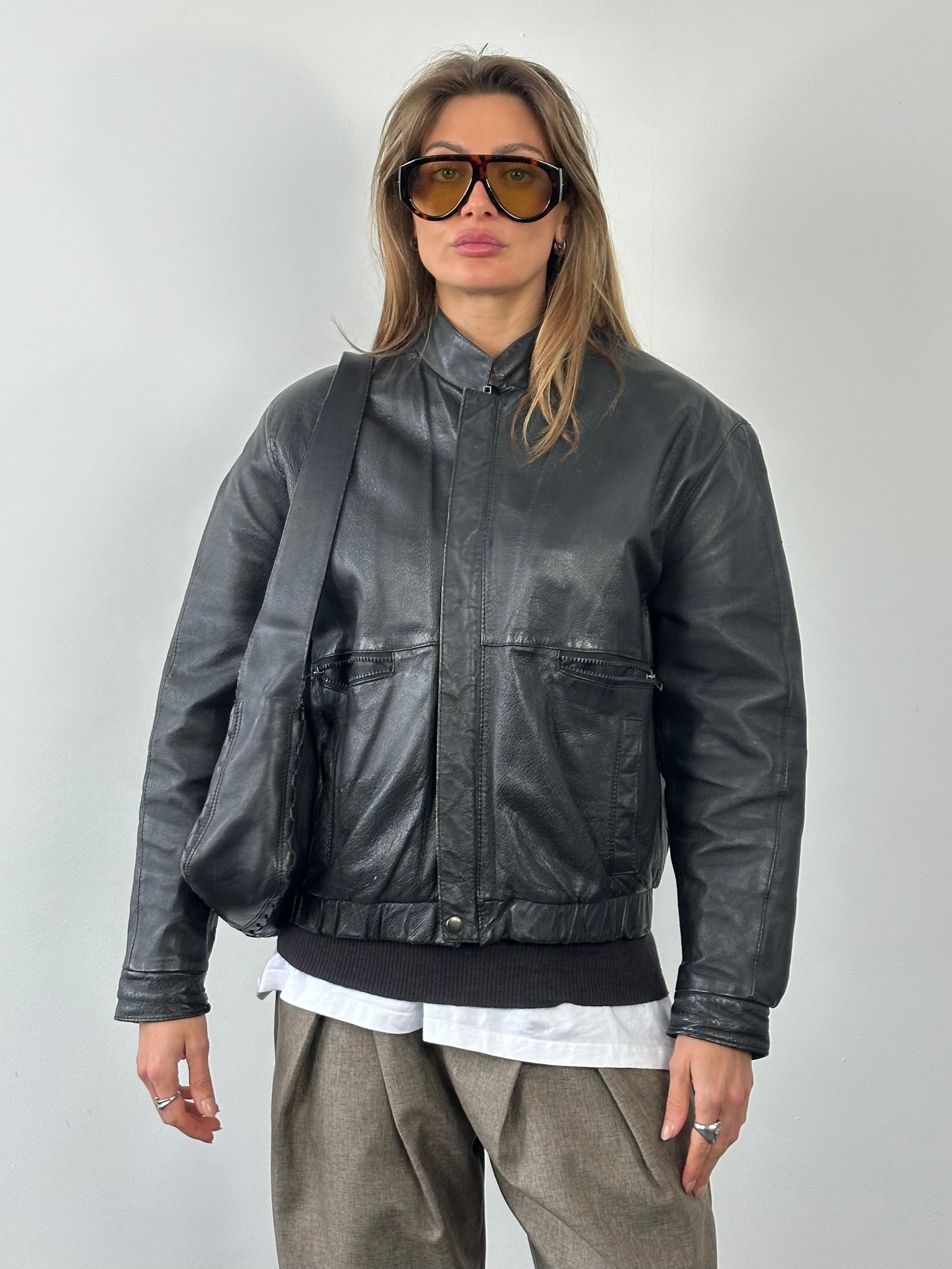 Vintage 1990s leather bomber jacket in size M, featuring classic design and brown leather material with ribbed cuffs and collar.