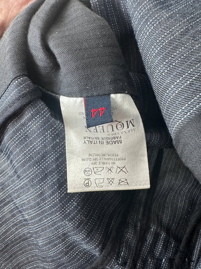 Close-up of a dark gray textured fabric garment showing a sewn-in size and care label. The label reads MOLLEEN and indicates size 44.