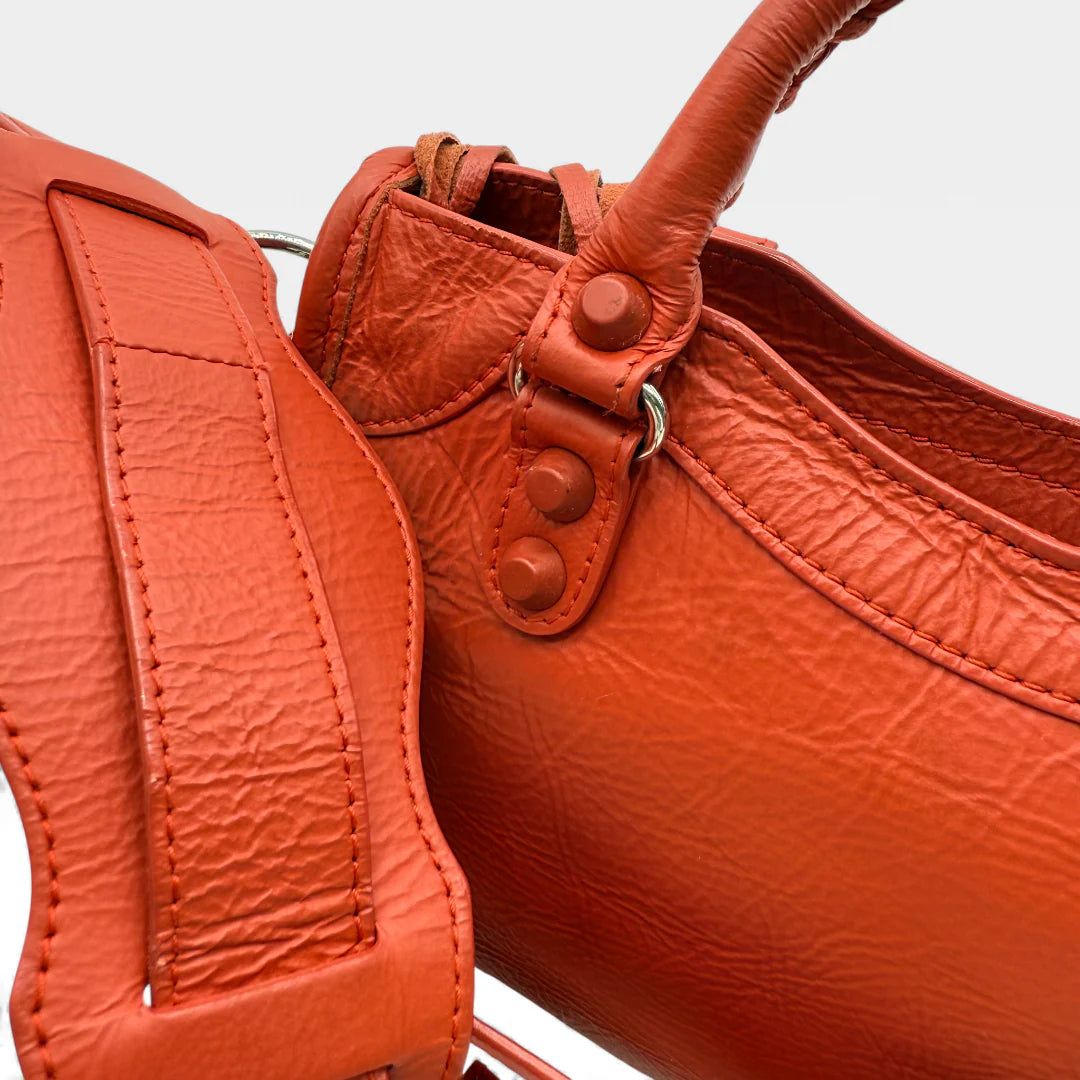 https://cdn.shopify.com/s/files/1/0564/9376/8855/files/Balenciaga_Handtasche_City_bag_small_aus_Lammleder_orange_vintage_handbag2711.webp?v=1762520503