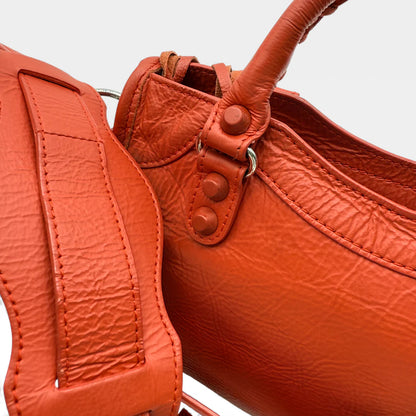 https://cdn.shopify.com/s/files/1/0564/9376/8855/files/Balenciaga_Handtasche_City_bag_small_aus_Lammleder_orange_vintage_handbag2711.webp?v=1762520503