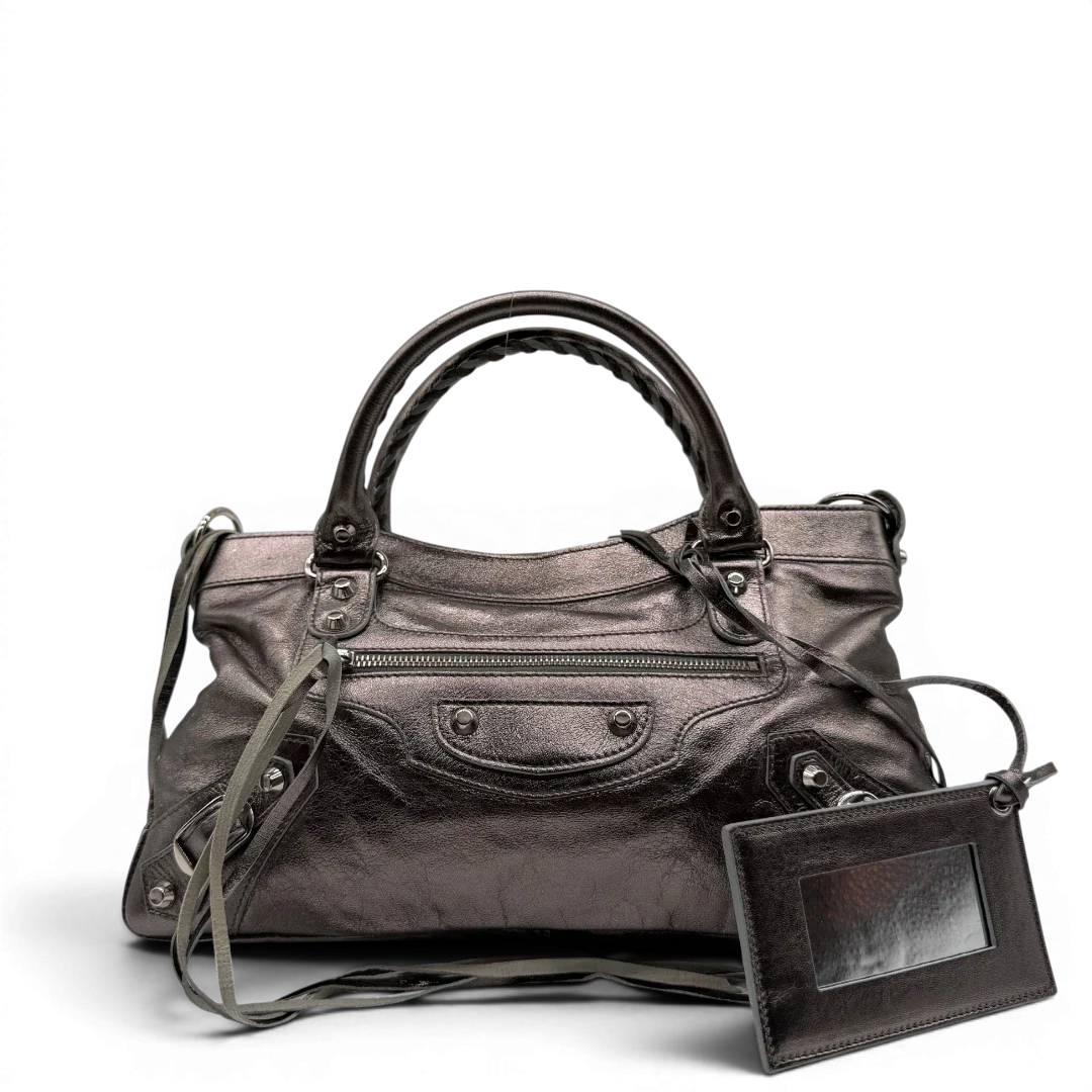 https://cdn.shopify.com/s/files/1/0564/9376/8855/files/Balenciaga_Handtasche_The_First_City_Bag_aus_Leder_silber___chrome_vintage6579.webp?v=1778675915