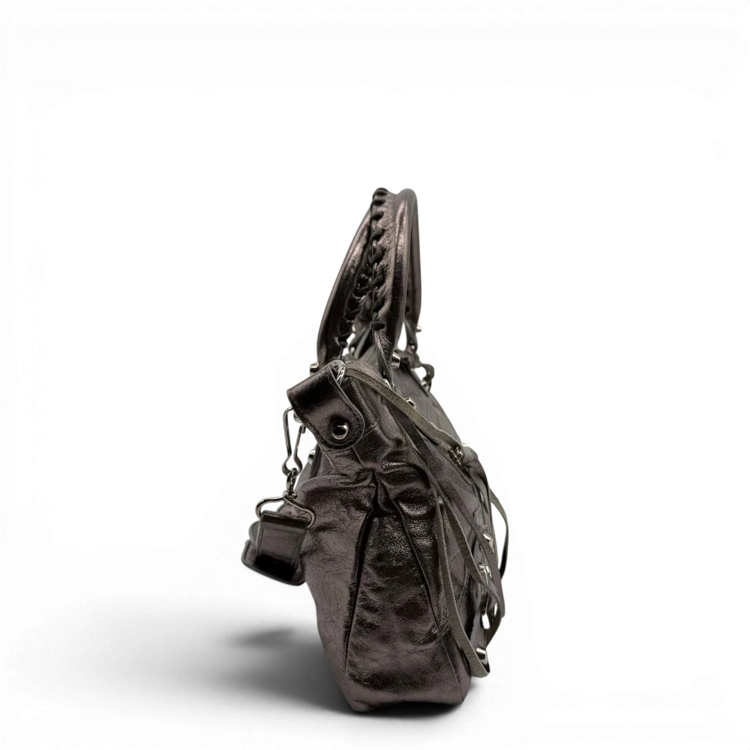 https://cdn.shopify.com/s/files/1/0564/9376/8855/files/Balenciaga_Handtasche_The_First_City_Bag_aus_Leder_silber___chrome_vintage6583.webp?v=1778675915