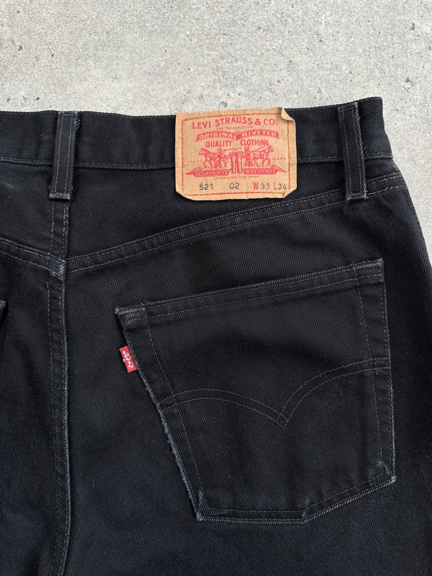 Levi’s 521 tapered straight leg denim jeans in W31, shown on a hanger with a dark wash and classic five-pocket style.