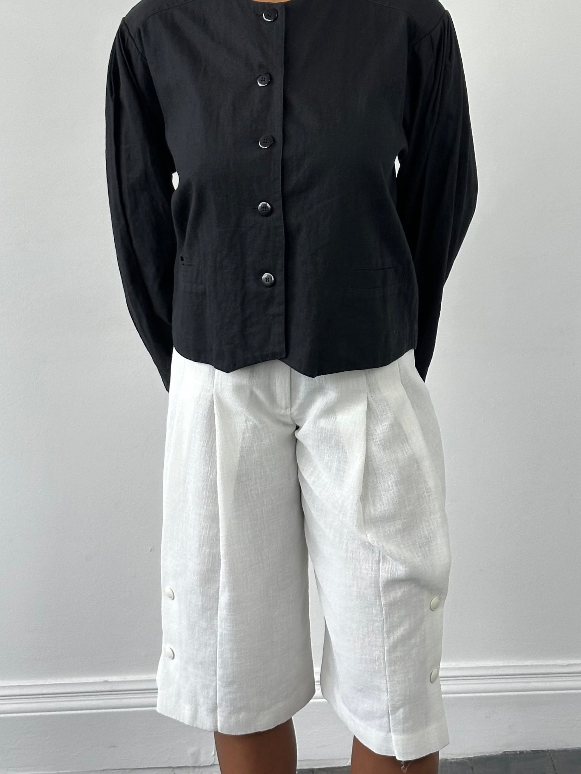 Vintage Japanese 1990s high-waisted pleated culottes shorts in beige, with wide legs and retro high waist for a classic look.
