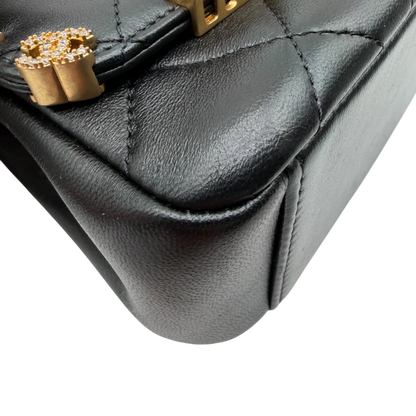 https://cdn.shopify.com/s/files/1/0564/9376/8855/files/Chanel_Handtasche_Cruise_23C_Mini_Flap_bag_mit_Emaille-_und_Strassdetails_aus_Lammleder_schwarz_vintage_CC7186_d83ee5ec-f649-452b-93b0-f13f7be0055e.webp?v=1779959982