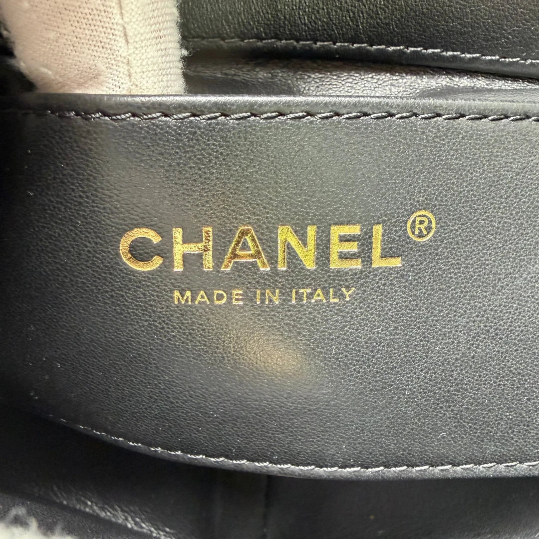 https://cdn.shopify.com/s/files/1/0564/9376/8855/files/Chanel_Handtasche_Cruise_23C_Mini_Flap_bag_mit_Emaille-_und_Strassdetails_aus_Lammleder_schwarz_vintage_CC7197_743c9470-3ca3-492c-a95f-3f1d99f55eda.webp?v=1779959983