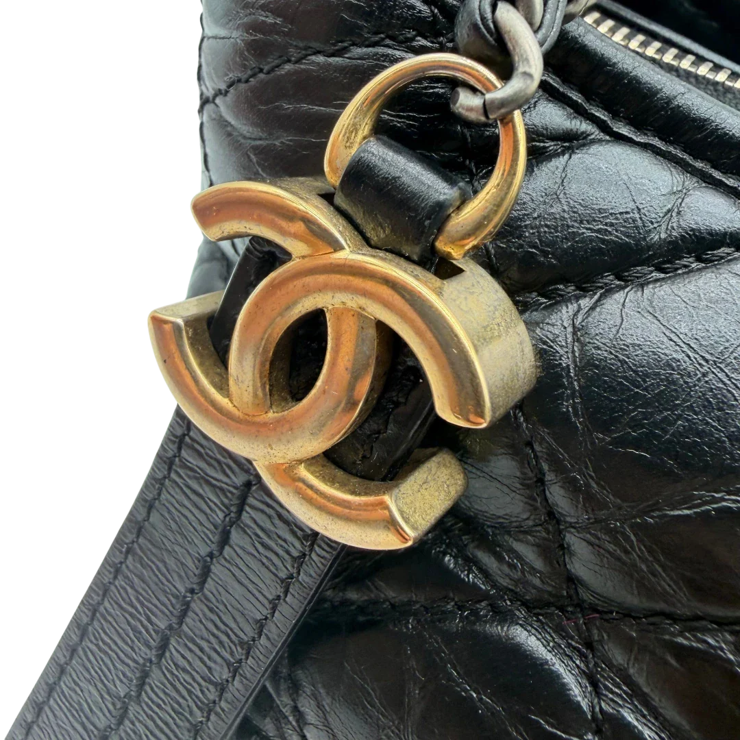 https://cdn.shopify.com/s/files/1/0564/9376/8855/files/Chanel_Schultertasche_Gabrielle_Hobo_aus_Lammleder_schwarz_vintage_CC7321.webp?v=1779963906
