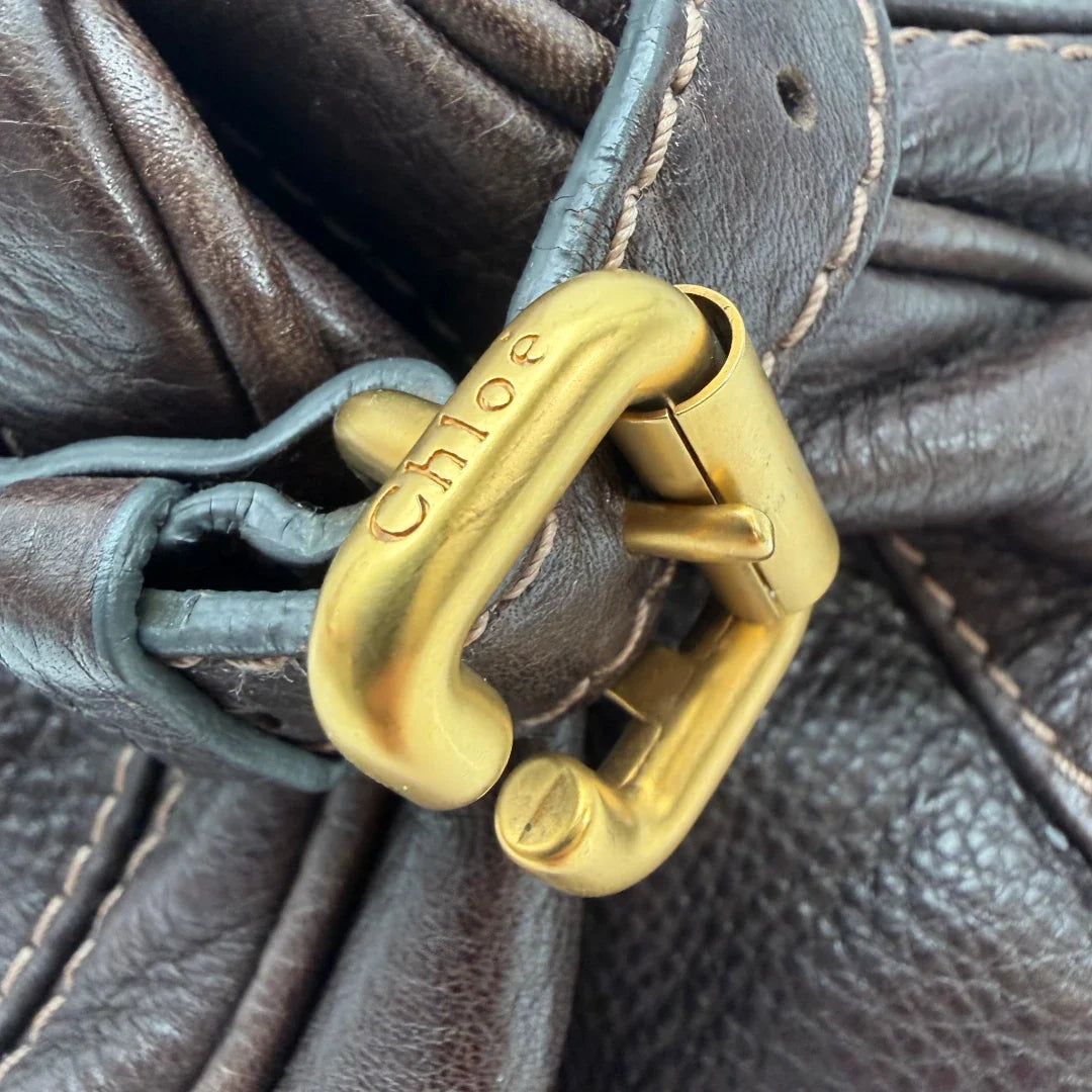 https://cdn.shopify.com/s/files/1/0564/9376/8855/files/Chloe_Handtasche_Paddington_aus_Leder_dunkelbraun_vintage6995.webp?v=1779290033